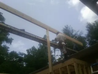 Carpenter setting a ridge beam over a new addition frame — Ice Dam Removal by Roofing Brothers in Glen Carbon