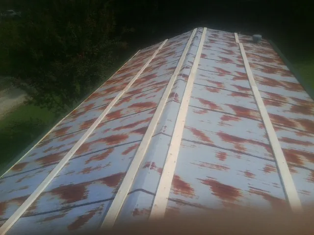 Rusted metal roof panels with new wood purlins before replacement — Storm Damage Roof Repair in Glen Carbon by Roofing Brothers