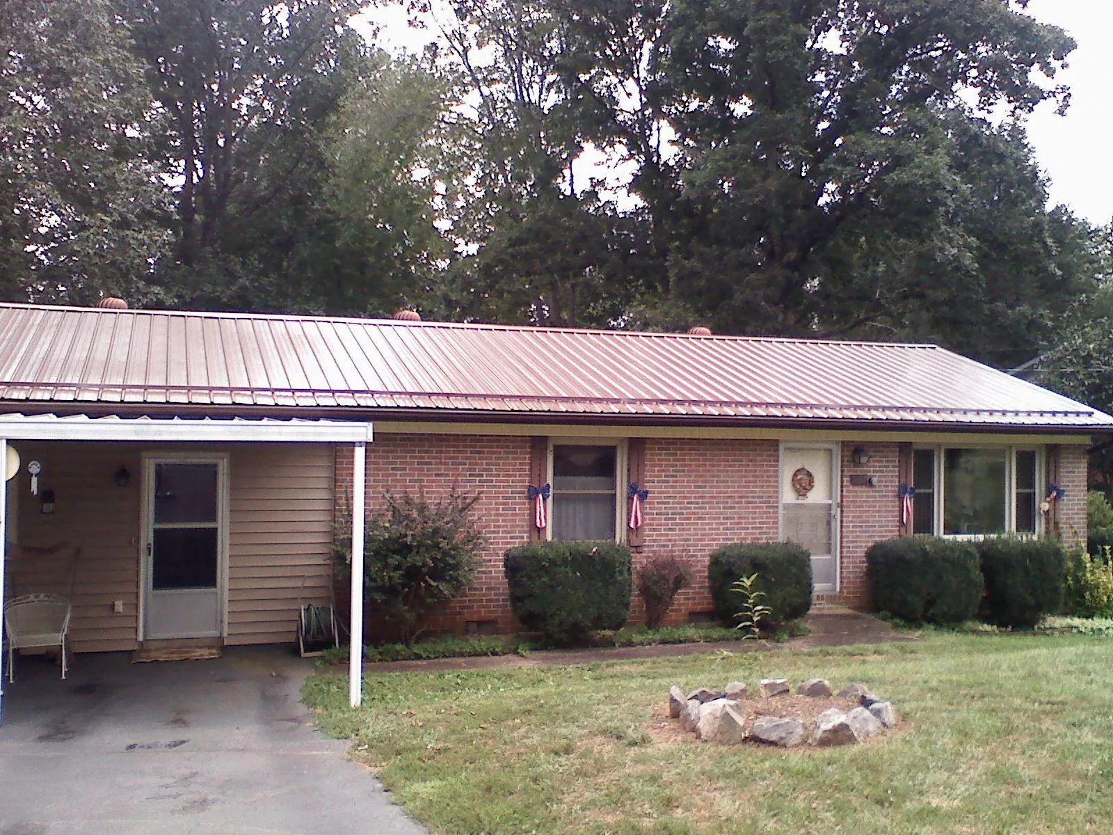 Bronze metal roof and carport on a brick ranch home — Roof Repair work by our crew in Glen Carbon